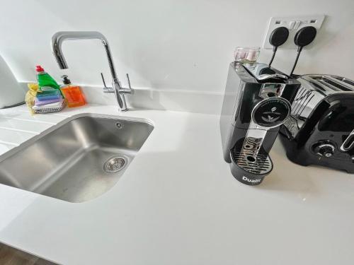 a kitchen counter with a sink and a toaster at ENTR - Modern Apartments in Windsor in Windsor