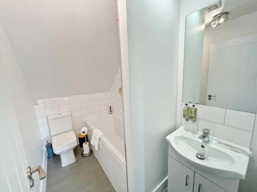 a bathroom with a sink and a tub and a toilet at ENTR - Modern Apartments in Windsor in Windsor