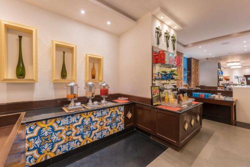 a restaurant with a counter with vases on the wall at Radisson Goa Candolim in Candolim