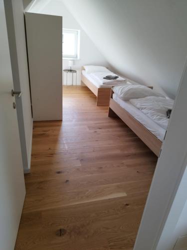 a bedroom with two beds and a wooden floor at Krems am Campus in Krems an der Donau