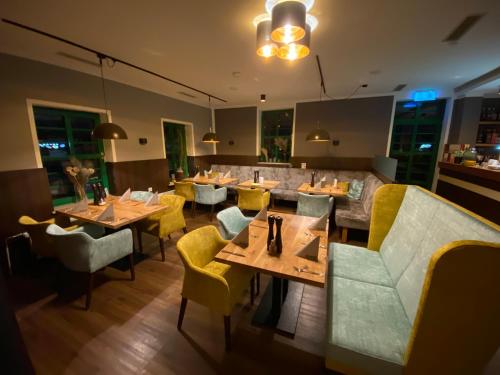 a restaurant with wooden tables and yellow chairs at Hotel & Restaurant Elbschetal in Wetter