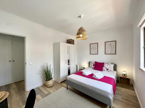 - une chambre avec un grand lit et des draps roses dans l'établissement Albufeira Design by Homing, à Albufeira