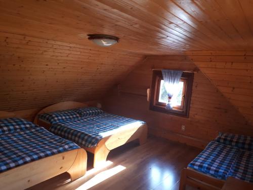 a room with two beds in a wooden cabin at Chata Dreváčik in Svit