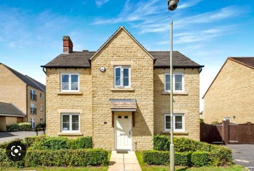 a brick house with a white door at Hibiscus House in Shilton