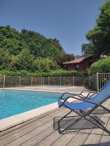 une chaise bleue assise sur une terrasse à côté d'une piscine dans l'établissement Résidence Nature et tranquillité, à Messanges