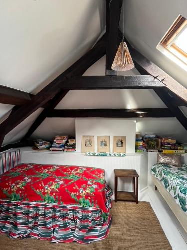 una camera da letto con letto rosso in mansarda di ‘L’ éditeur’ - Maison de Maître Honfleuraise. a La Rivière Saint Sauveur