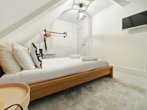 a bedroom with a bed with white sheets and pillows at ENTR - Modern Apartments in Windsor in Windsor