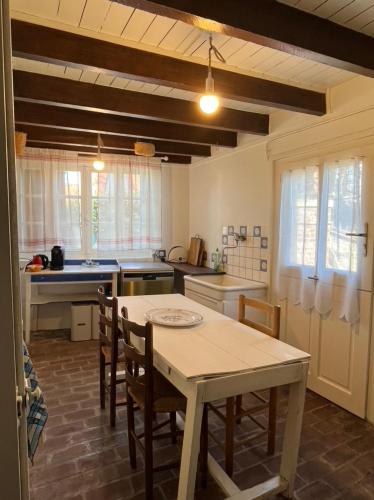 une cuisine avec une table et des chaises dans l'établissement ‘L’ éditeur’ - Maison de Maître Honfleuraise., à La Rivière-Saint-Sauveur
