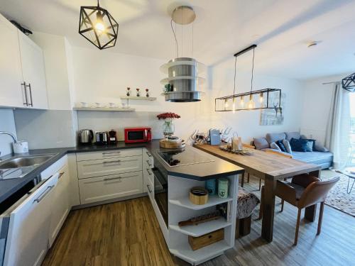 a kitchen with a wooden table and a dining room at Neue Ferienwohnung mit Whirlpool und Sauna in der Residenz Grafenmatt inklusive HochschwarzwaldCard in Feldberg