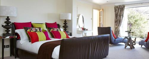 a bedroom with a large bed with colorful pillows at Stargazers in Saint Mawes