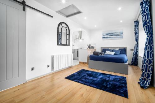 a living room with a bed and a blue rug at Luxury cosy apartment in Birmingham