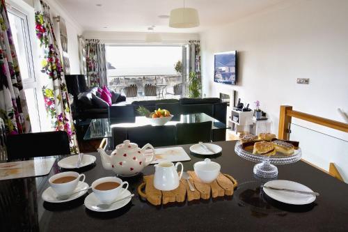a living room with a table with cups and saucers at Shellseekers in Saint Mawes