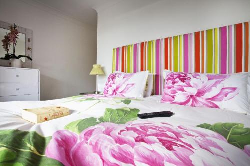 a bedroom with a bed with pink flowers on it at Shellseekers in Saint Mawes