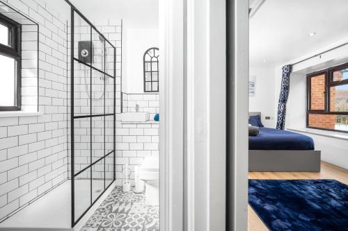 a bathroom with a shower and a bed in a room at Luxury cosy apartment in Birmingham