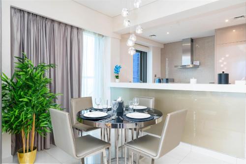 ein Esszimmer mit einem Tisch und Stühlen sowie eine Küche in der Unterkunft GLOBALSTAY DAMAC Towers by Paramount in Business Bay in Dubai