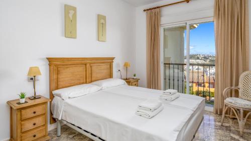 een slaapkamer met een bed met twee handdoeken erop bij Seaview apt with pool by Costarentals - Ref 188 in La Cala de Mijas