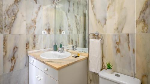 een badkamer met een wastafel en een spiegel bij Seaview apt with pool by Costarentals - Ref 188 in La Cala de Mijas