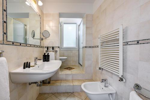 a bathroom with a sink and a toilet and a mirror at Hotel Metropolitan in Bologna