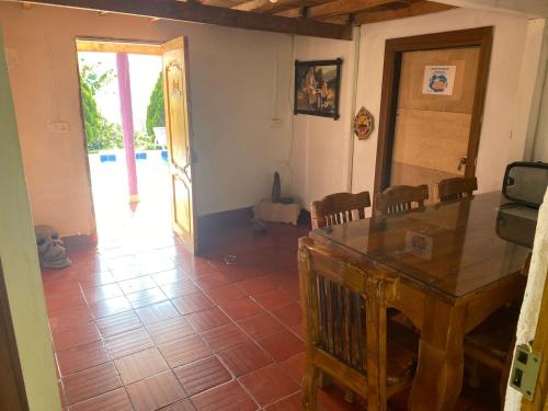 a living room with a wooden table and a door at alojamiento rural finca ayapel in Verdún