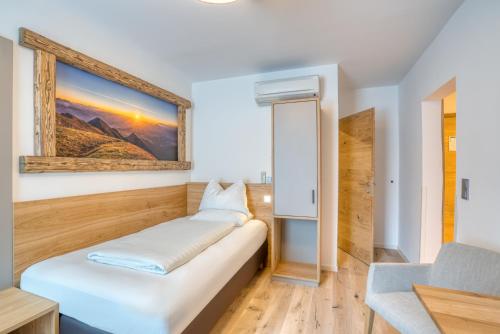 a bed in a room with a picture on the wall at Leipziger Hof Innsbruck in Innsbruck
