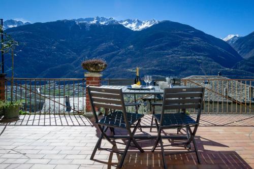 PoggiridentiにあるPanoramic Apartment Italian Alps Valtellina near Sondrio, Tiranoの山の景色を望むバルコニー(テーブル、椅子付)