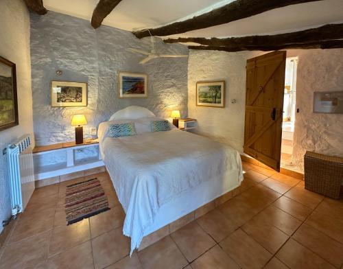 a bedroom with a white bed and a window at Wonderful comfortable finca in the Burga valley in Rasquera