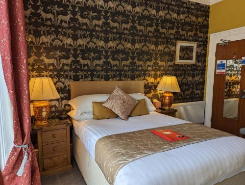 a bedroom with a bed with a red folder on it at Abingdon House in Torquay