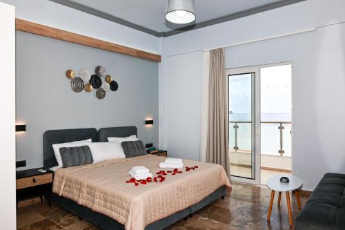 una camera da letto con un letto con rose rosse di Queen Mary Beachfront Studios a Chania