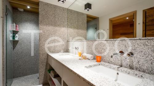 シャモニー・モンブランにあるChalet Graniteのバスルーム(シンク2台、大きな鏡付)