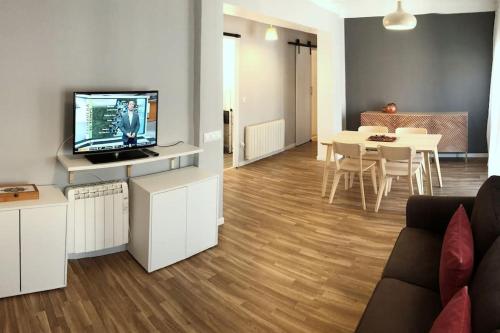 - un salon avec un canapé, une télévision et une table dans l'établissement El Balcó del Bastareny Apartamento renovado 6p, à Guardiola de Berguedà
