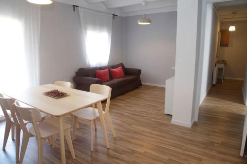 ein Wohnzimmer mit einem Tisch und einem Sofa in der Unterkunft El Balcó del Bastareny Apartamento renovado 6p in Guardiola de Berga