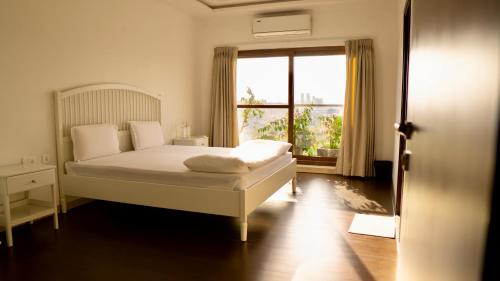 a bedroom with a bed and a large window at Bridge Service Apartment in Hyderabad