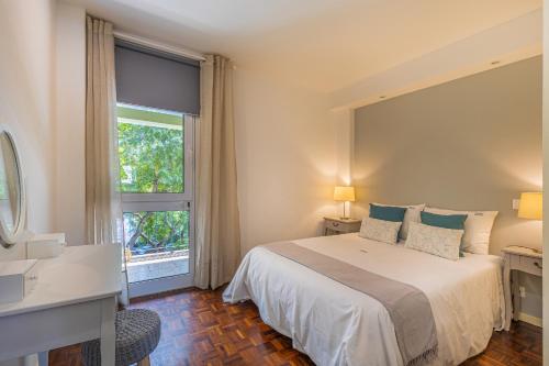 Un dormitorio con una cama grande y una ventana en Flat with Balcony at Downtown by Farmers Market, en Santa Luzia