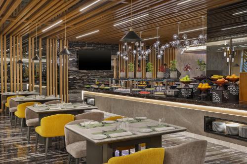a restaurant with tables and chairs and a bar at Holiday Inn & Suites - Al Khobar by IHG in Al Khobar