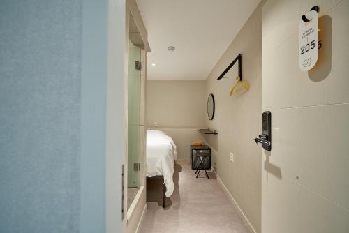 a hallway with a bed and a door to a room at Life in Euljiro in Seoul