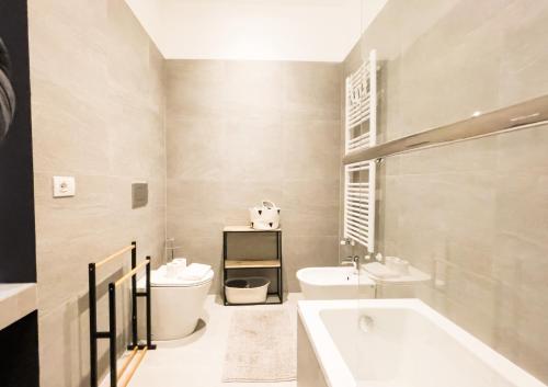 a bathroom with a tub and a toilet and a sink at Easylife - Elegante e rifinita Dimora nello splendido quartiere di Porta Venezia in Milan