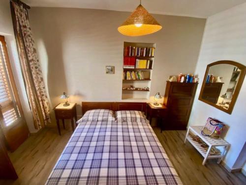 Un dormitorio con una cama con una manta a cuadros. en CASA CELSA, en Mongiove