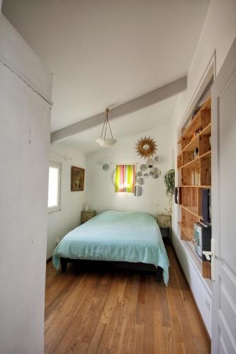 une chambre avec un lit et une télévision dans l'établissement Le Jardin Suspendu Gîte avec piscine et jacuzzi pour 15 personnes, à Vailhauquès