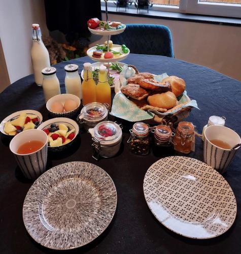 een tafel met borden met eten en drinken bij Het Blij Hoen in Oudenbosch