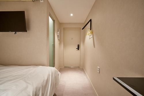 a bedroom with a bed and a door with a television at Life in Euljiro in Seoul