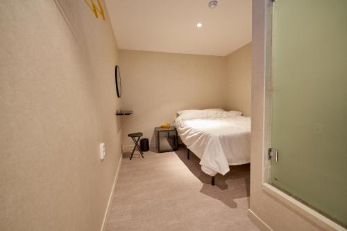 a small bedroom with a bed and a hallway at Life in Euljiro in Seoul
