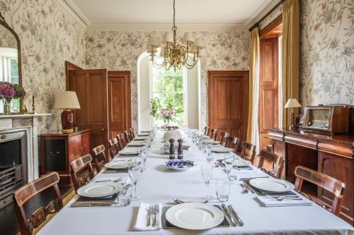 uma longa sala de jantar com uma longa mesa e cadeiras em Finest Retreats - Tresillian House em Newquay
