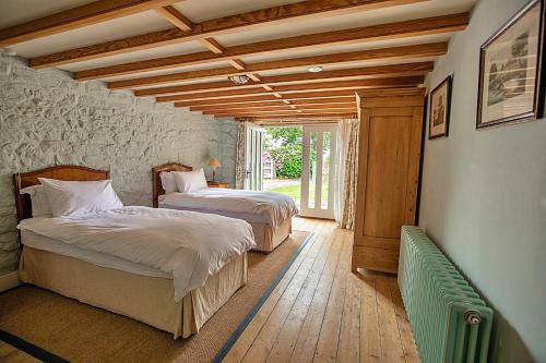 a bedroom with two beds in a room with wooden ceilings at Finest Retreats - The Apple Store in Newquay