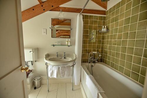 a bathroom with a sink and a bath tub at Finest Retreats - The Apple Store in Newquay