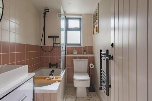 a bathroom with a toilet and a sink and a shower at Victory Cottage - Stunning home with sea views in Kingsdown