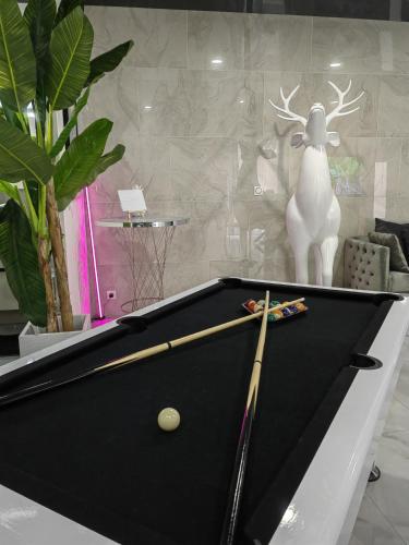 a pool table with two cuesticks on top of it at Maloveroom, 2 Suites d'exceptions in Beaucroissant