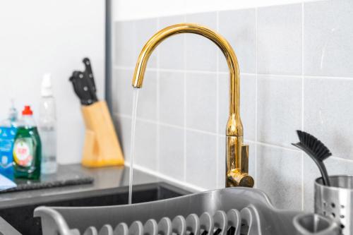 a kitchen sink with a gold faucet at BROADWAY SUITE - Newly refurbished stylish apartment with FREE PRIVATE PARKING - Great location in Birmingham