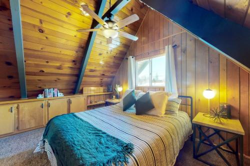 a bedroom with a bed with a ceiling fan at Big Bear Bungalow in Big Bear City