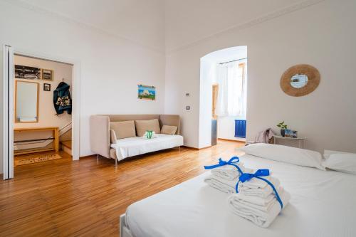 ein weißes Zimmer mit 2 Betten und einem Sofa in der Unterkunft Marina Terrace Apartment in Mola di Bari