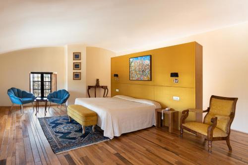 1 dormitorio con 1 cama, 2 sillas y mesa en Castello Di Petroia Dimora d'Epoca, en Gubbio